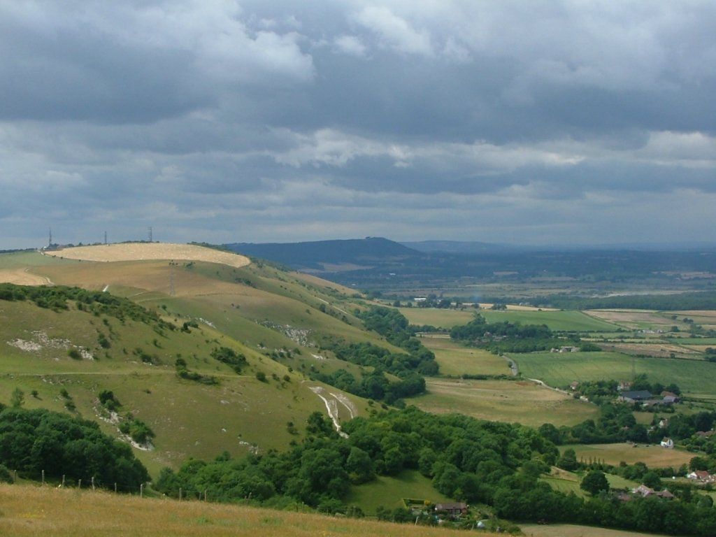 Rounded green slopes of the South Downs above a patchwork of fields in Sussex